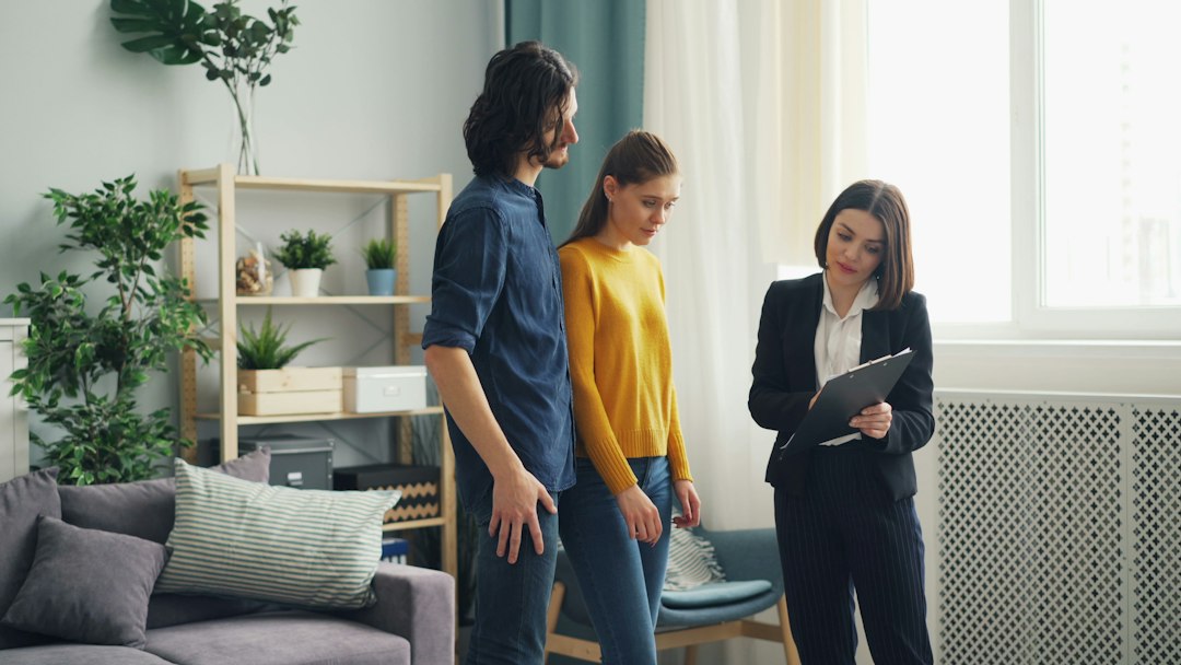 Three adults reviewing paperwork together during a home visit